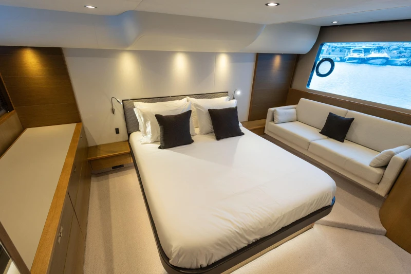Luxurious bedroom interior of 2014 Princess 56 yacht with elegant furnishings and large window view.
