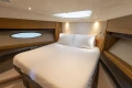 Luxurious cabin interior of 2014 Princess 56 yacht with cozy bed and ambient lighting.