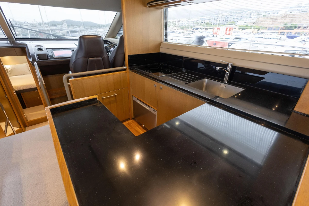Luxurious kitchen interior of 2014 Princess 56 yacht with sleek black countertops.
