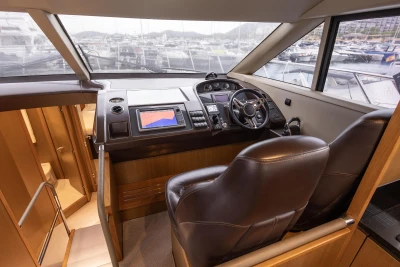 Interior of 2014 Princess 56 yacht cockpit with steering wheel and navigation system.