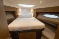 Luxurious bedroom interior of 2014 Princess 56 yacht with elegant wood finishes.