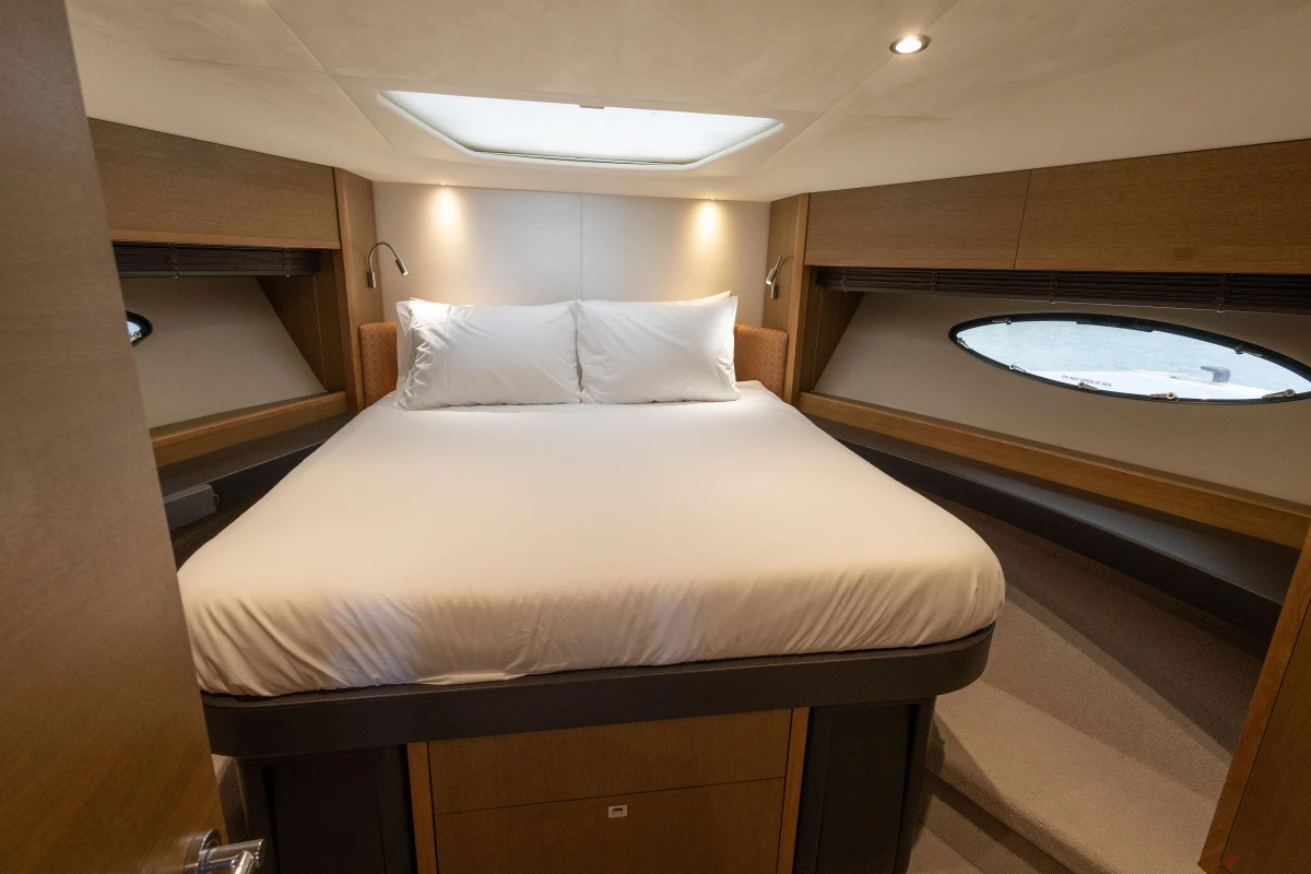 Luxurious bedroom interior of 2014 Princess 56 yacht with elegant wood finishes.