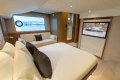 Luxurious 2014 Princess 56 yacht bedroom with modern decor and scenic window view.