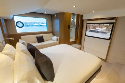 Luxurious 2014 Princess 56 yacht bedroom with modern decor and scenic window view.
