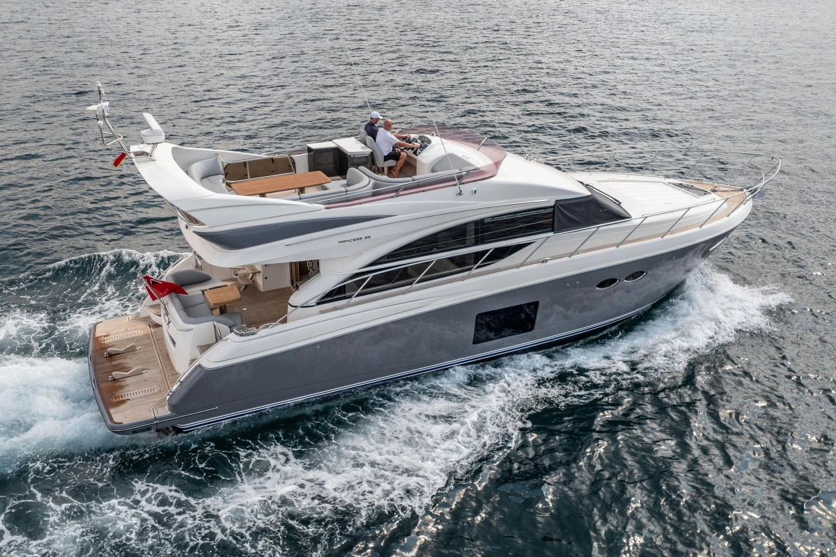 Luxurious 2014 Princess 56 yacht cruising on open water, showcasing sleek design and elegance.
