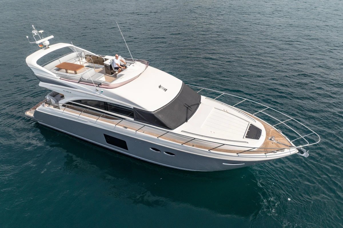 Luxury 2014 Princess 56 yacht cruising on open sea, featuring sleek design and spacious deck.
