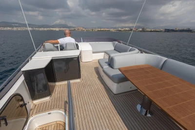 Luxurious 2014 Princess 56 yacht deck with seating and table, cruising on calm waters.