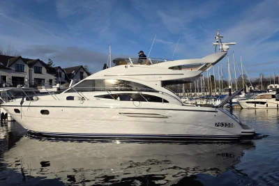 2006 Princess 42 Flybridge Motor Yacht docked in a marina, under a clear blue sky.