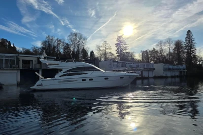 2006 Princess 42 Flybridge Motor Yacht on serene water at sunset.