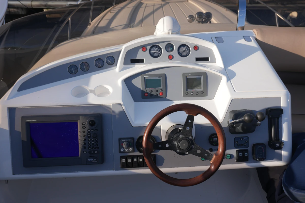 Helm of 2006 Princess 42 Flybridge Motor Yacht with navigation instruments and wooden steering wheel.
