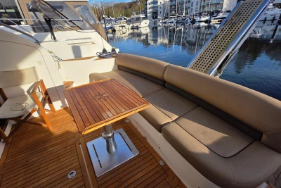 Luxurious 2006 Princess 42 Flybridge Motor Yacht with elegant seating and wooden table.