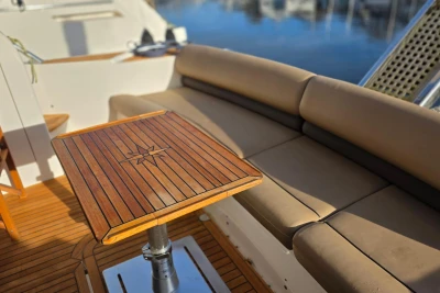 Luxurious seating area on 2006 Princess 42 Flybridge Motor Yacht with wooden table.