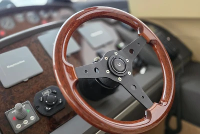 Steering wheel of a 2006 Princess 42 Flybridge Motor Yacht, featuring wood and metal design.