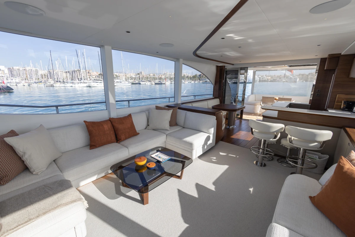 Luxurious interior of 2026 Princess Y72 yacht with marina view, featuring elegant seating and modern design.