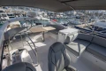 Luxurious 2023 Princess F50 yacht interior with seating and table, docked at marina.