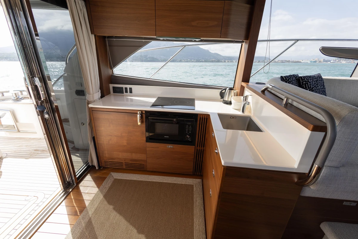 Luxurious kitchen interior of 2023 Princess F50 yacht with modern appliances and ocean view.
