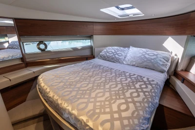Luxurious bedroom interior of 2023 Princess F50 yacht with elegant bedding and wood accents.