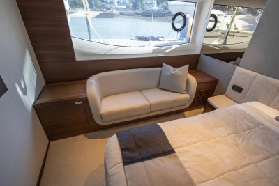 Luxurious interior of 2023 Princess S72 yacht with sofa and window view.