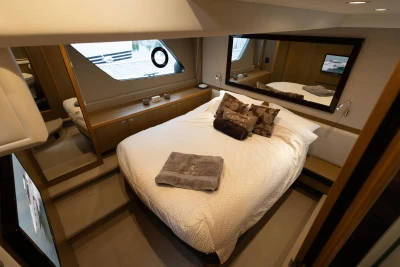 Luxurious bedroom interior of 2014 Princess V52 yacht with elegant bedding and modern design.