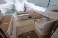 Luxurious 2014 Princess V52 yacht with elegant seating and wooden deck cruising on open water.