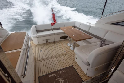 Luxurious 2014 Princess V52 yacht with elegant seating and wooden deck cruising on open water.