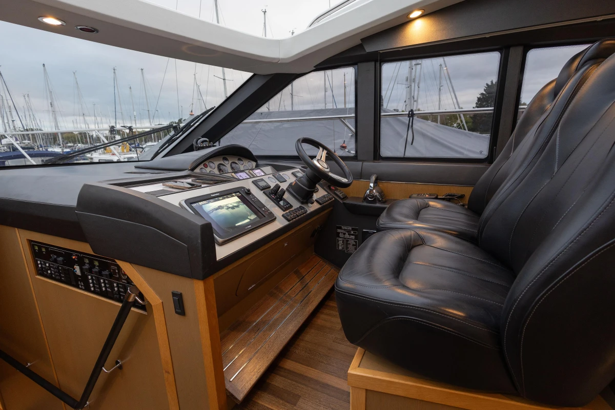 Luxurious 2014 Princess V52 yacht cockpit with leather seats and advanced navigation controls.