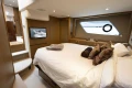 Luxurious bedroom interior of 2014 Princess V52 yacht with modern decor and large window.
