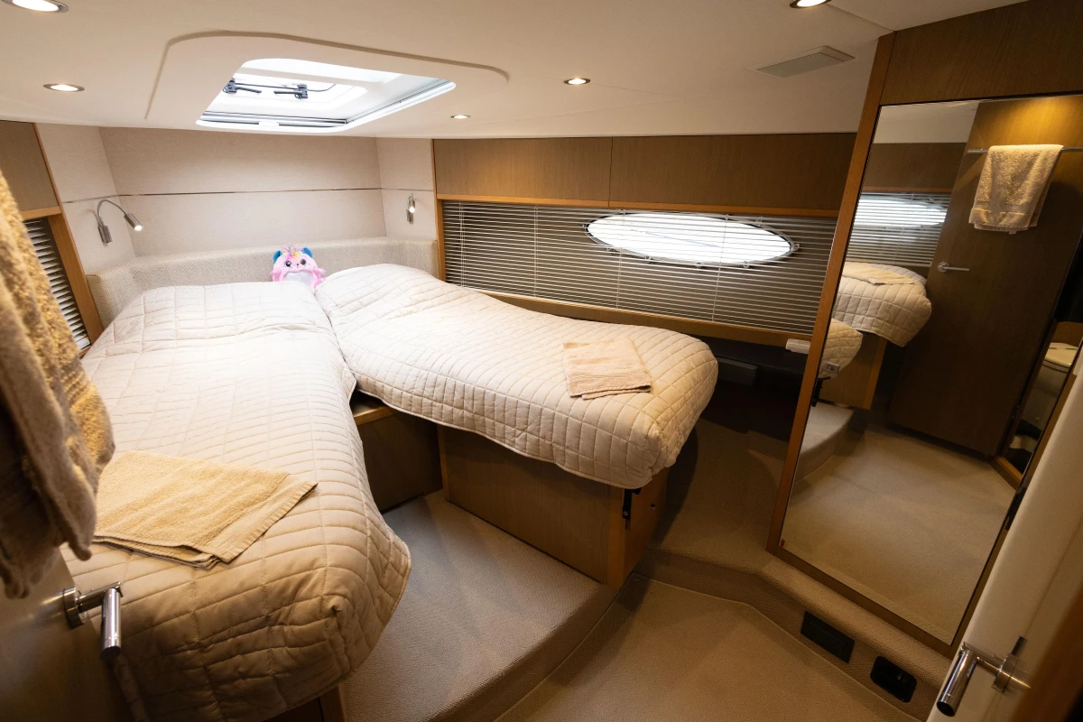 Luxurious 2014 Princess V52 yacht cabin with twin beds and modern decor.