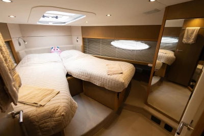Luxurious 2014 Princess V52 yacht cabin with twin beds and modern decor.