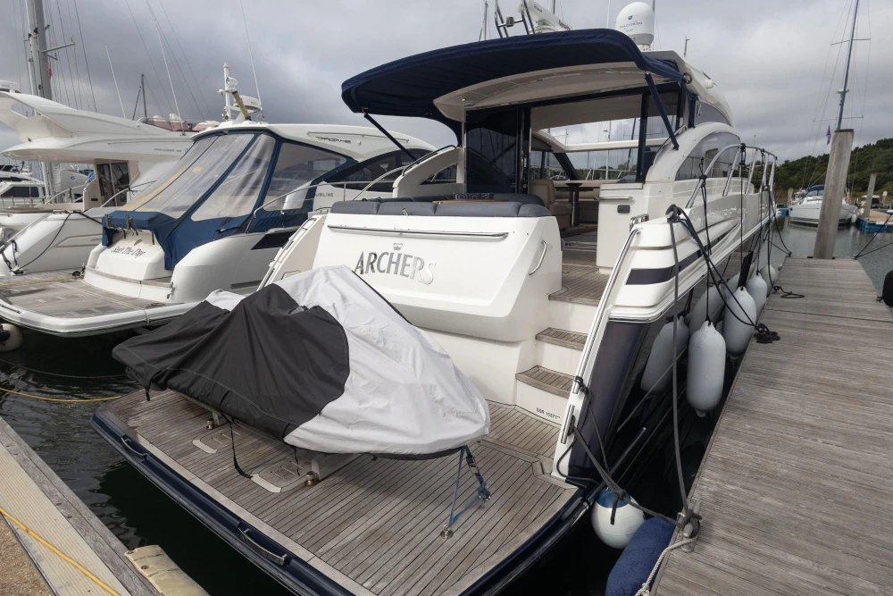 Luxury 2012 Princess V52 yacht docked at marina with covered jet ski.