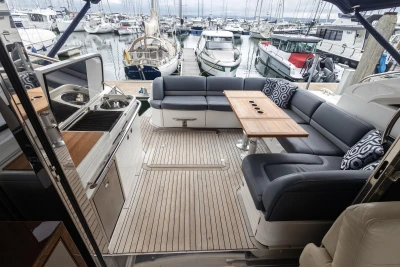 Luxurious 2012 Princess V52 yacht with elegant seating and dining area in a marina setting.