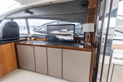 Luxurious interior of 2012 Princess V52 yacht with modern cabinetry and a flat-screen TV.