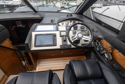 Helm of 2012 Princess V52 yacht with modern navigation equipment and luxurious leather seating.