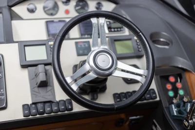 Steering wheel and dashboard of 2012 Princess V52 yacht, featuring modern controls and displays.
