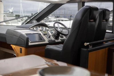 Interior cockpit of 2012 Princess V52 yacht with modern navigation equipment and leather seats.