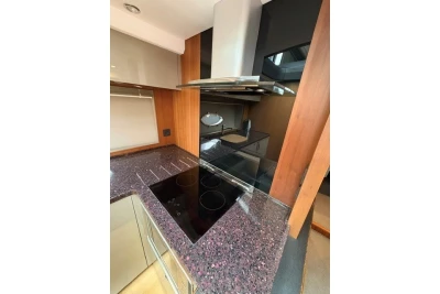 Modern kitchen in 2013 Princess V52 yacht with sleek cooktop and wood accents.