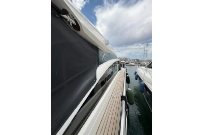 2013 Princess V52 yacht docked at marina, showcasing sleek design and wooden deck.