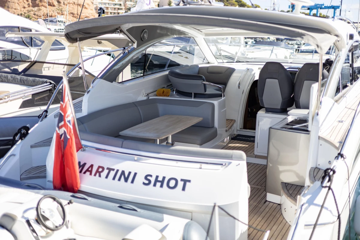 2017 Princess V40 yacht with seating area and flag, docked at marina.