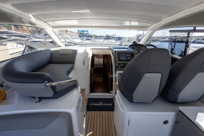 2017 Princess V40 yacht interior with helm, seating, and marina view.