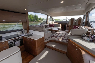 Interior of a luxury yacht with modern kitchen, cozy seating areas, and large windows.