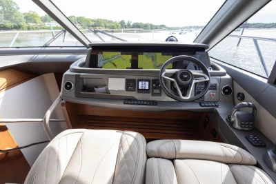 The image shows the cockpit of a 2022 Princess F55 yacht with modern navigation systems.