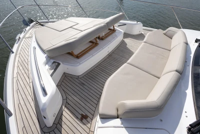 The image shows the foredeck of a 2022 Princess F55 yacht with beige cushions.