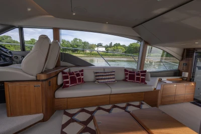Interior of a luxury yacht with comfortable seating and large windows overlooking the water.