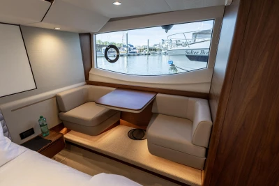 Interior of a luxurious cabin with a seating area and large window overlooking the marina.