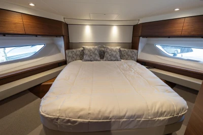 Luxurious cabin of the 2022 Princess F55 with a large bed and elegant wood accents.