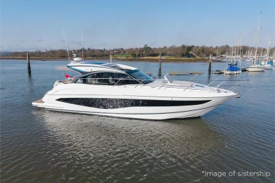 2026 Princess V50 yacht cruising on a calm river with scenic background.