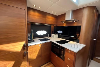 Luxurious 2017 Princess V48 Open yacht kitchen with modern appliances and elegant wood finish.