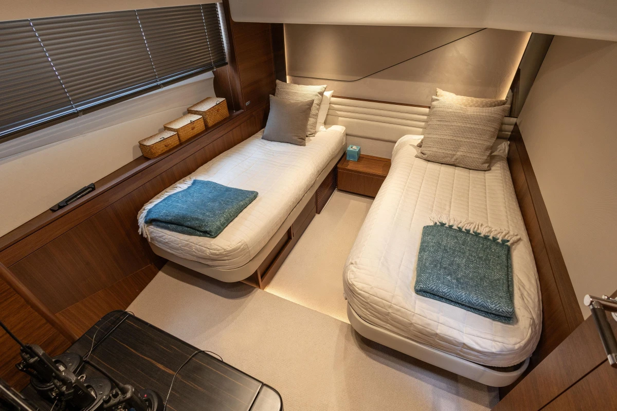 Luxurious 2022 Princess S78 yacht cabin with twin beds and elegant decor.