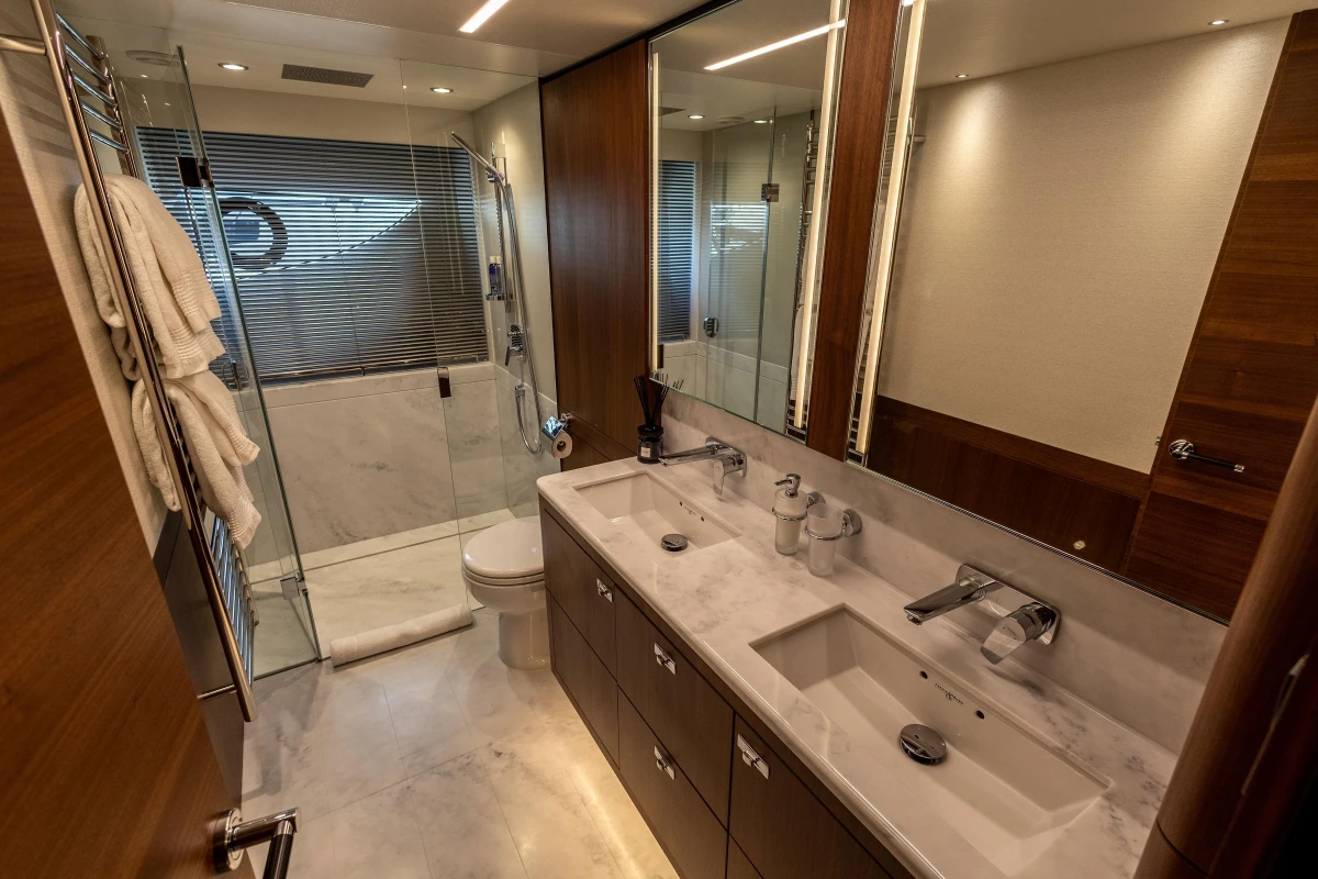Luxurious bathroom in 2022 Princess S78 yacht with dual sinks and glass shower.