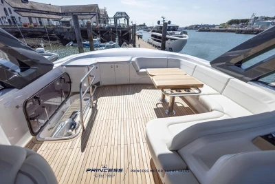 Luxurious 2023 Princess S72 yacht deck with elegant seating and table, docked at marina.
